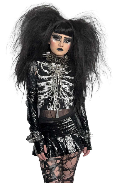 Person wearing a lip service black and silver skeleton-themed outfit with long hair on a white background