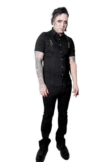 Person wearing a  lip service black outfit with tattoos on arms against a white background