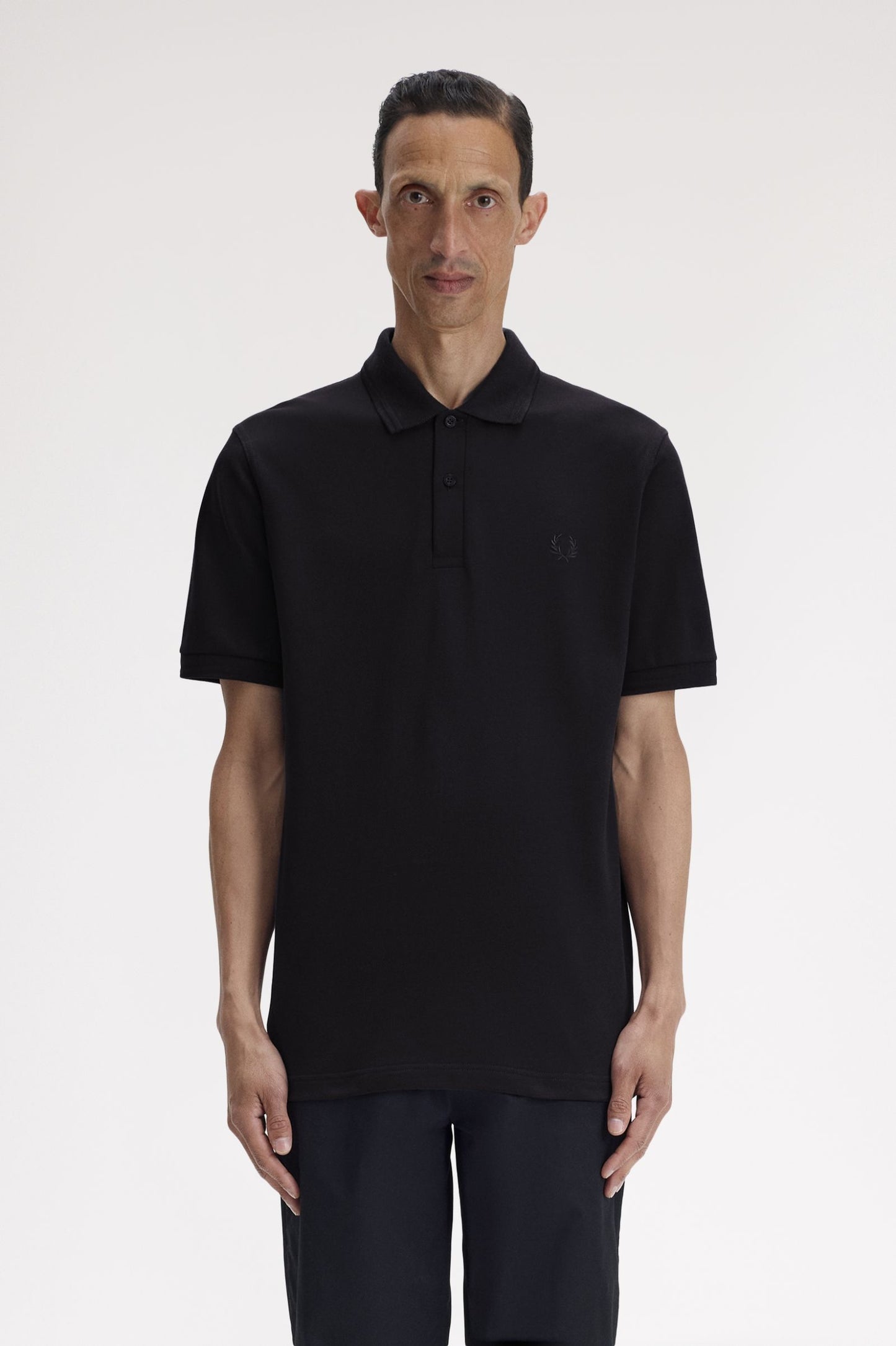 Man wearing a black polo shirt on a white background
