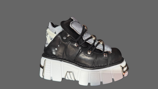 Black and white sneaker with thick sole on a gray background