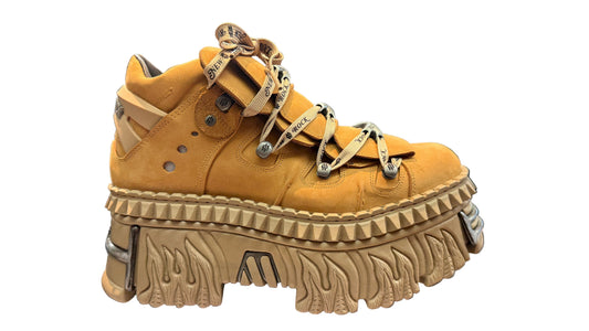 Tan platform sneaker with unique sole design on a display stand.