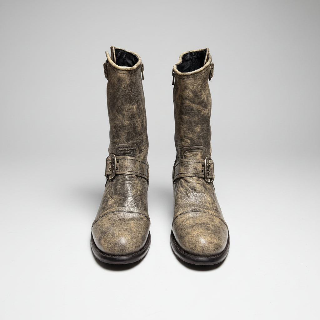 Pair of worn leather boots with buckles on a white background