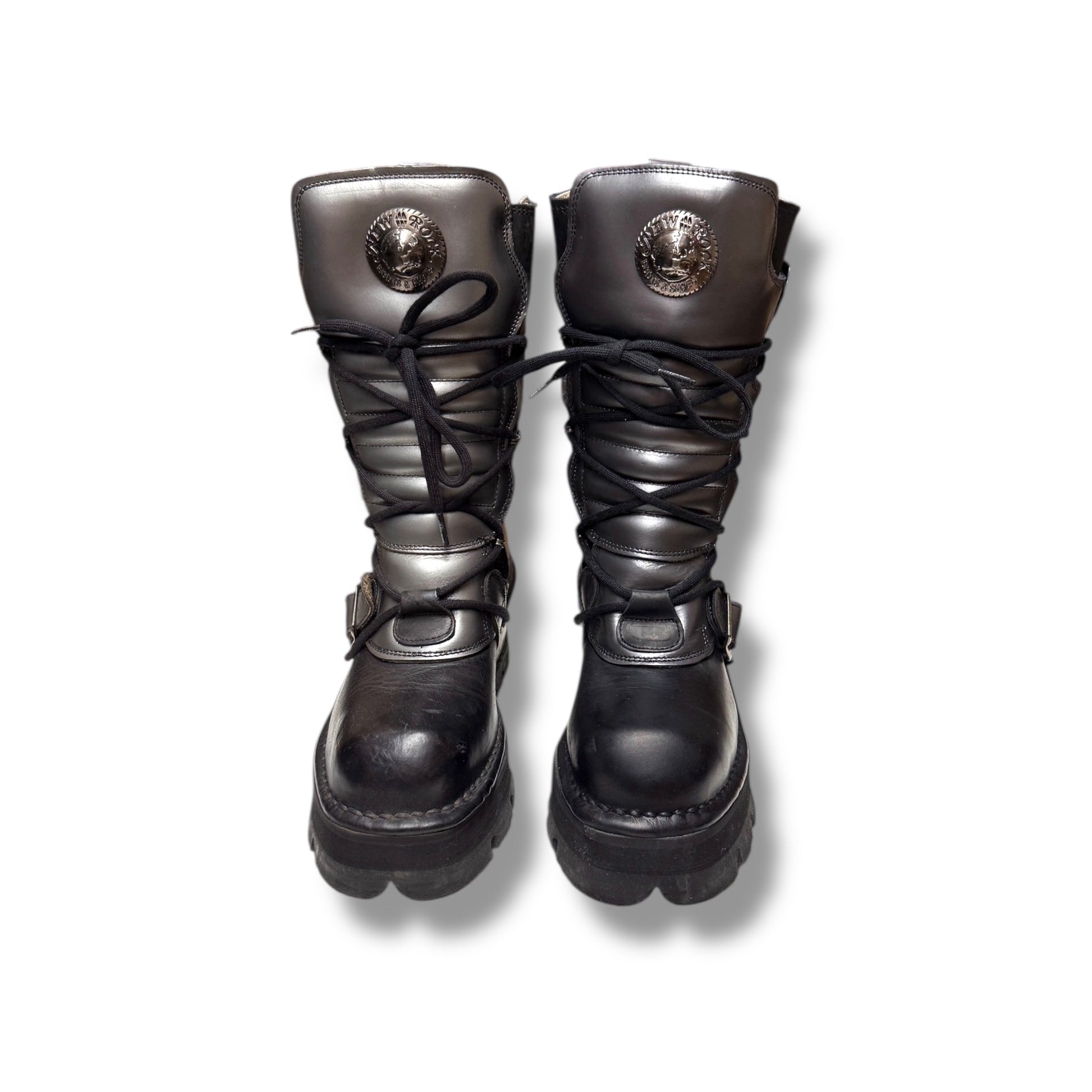 Pair of black leather boots with metal accents on a white background