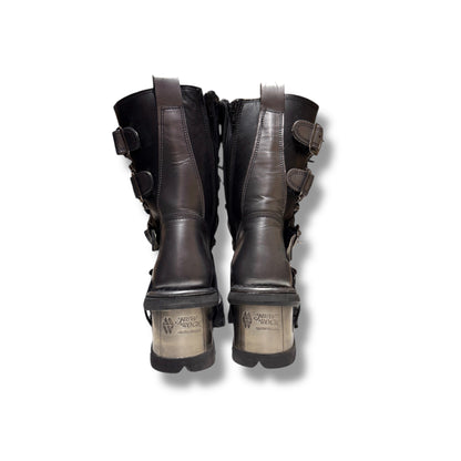 Pair of dark brown leather boots with buckles on a white background