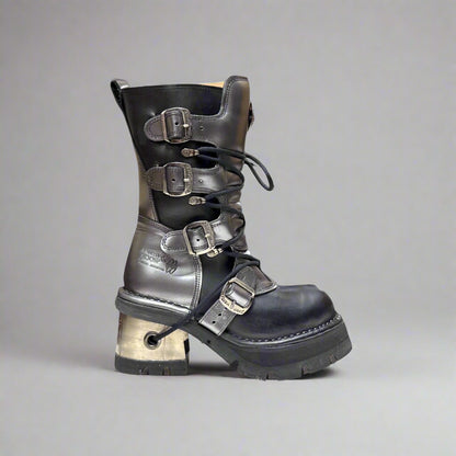 Black leather boot with metal buckles on a gray background