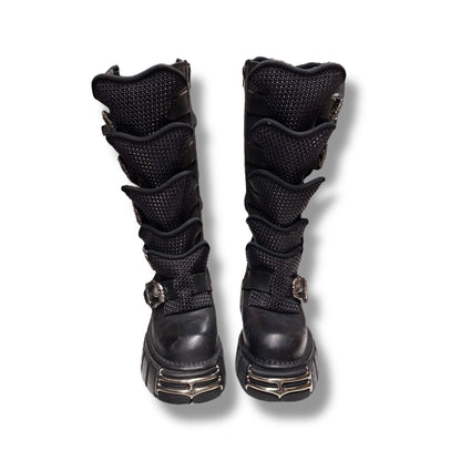 Pair of black knee-high boots with multiple straps on a white background