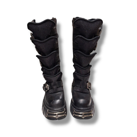 Pair of black knee-high boots with multiple straps on a white background