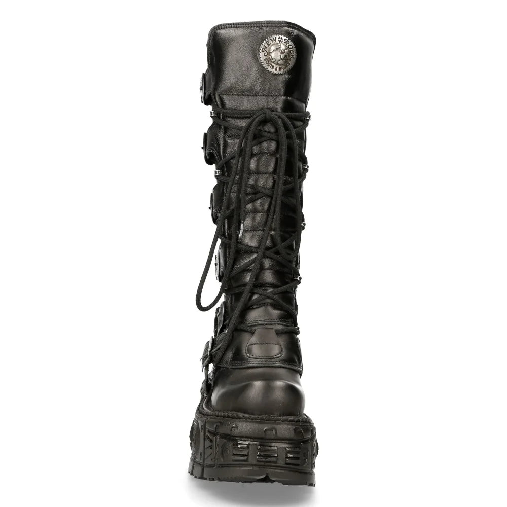 A single black leather combat boot with a chunky lug sole, lace-up front, and a circular metallic emblem on the collar, shown against a plain white background.