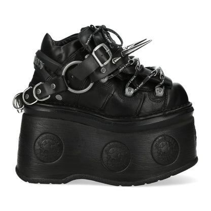 Black platform boot with straps and spikes on a white background