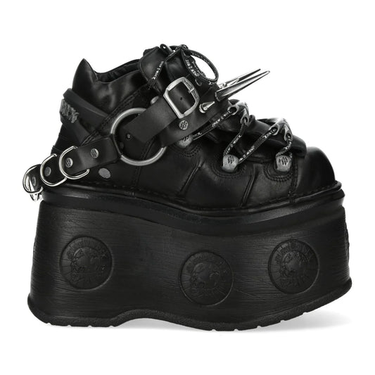 Black platform boot with straps and spikes on a white background