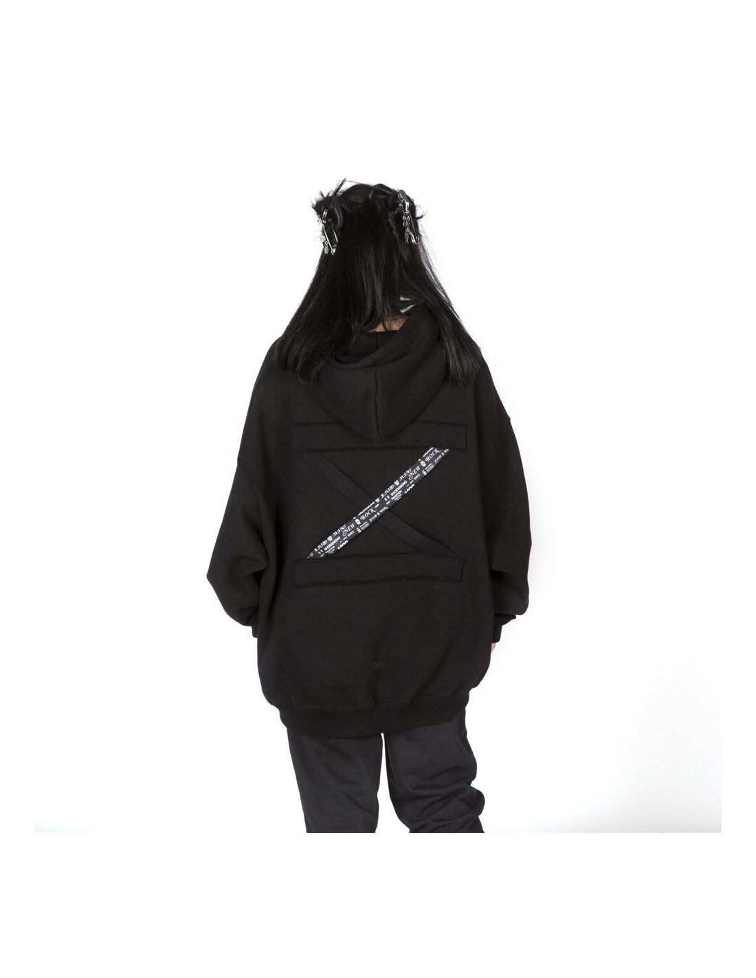 Person wearing a black hoodie with a white design on the back against a white background