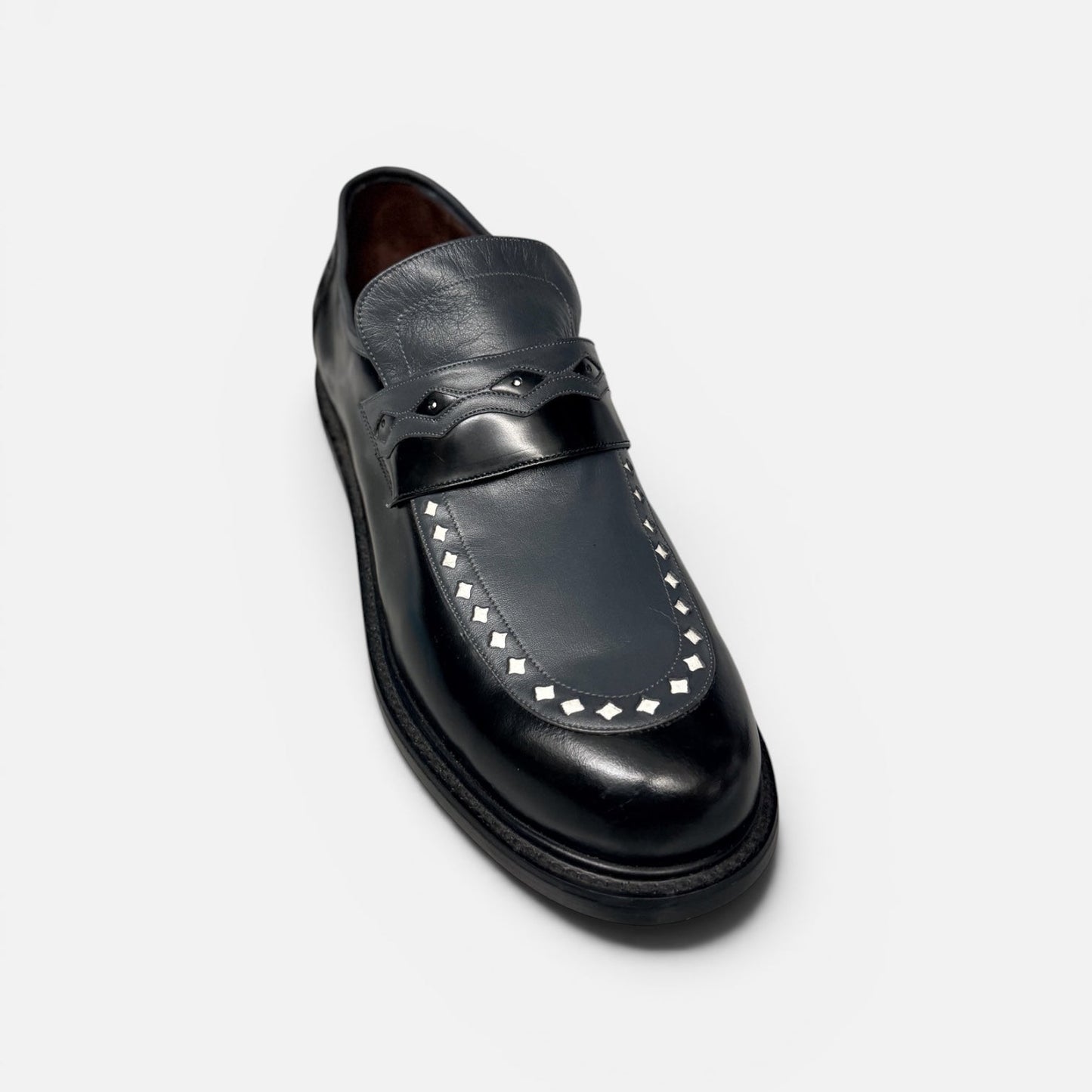 Black leather loafer with studded detail on a white background