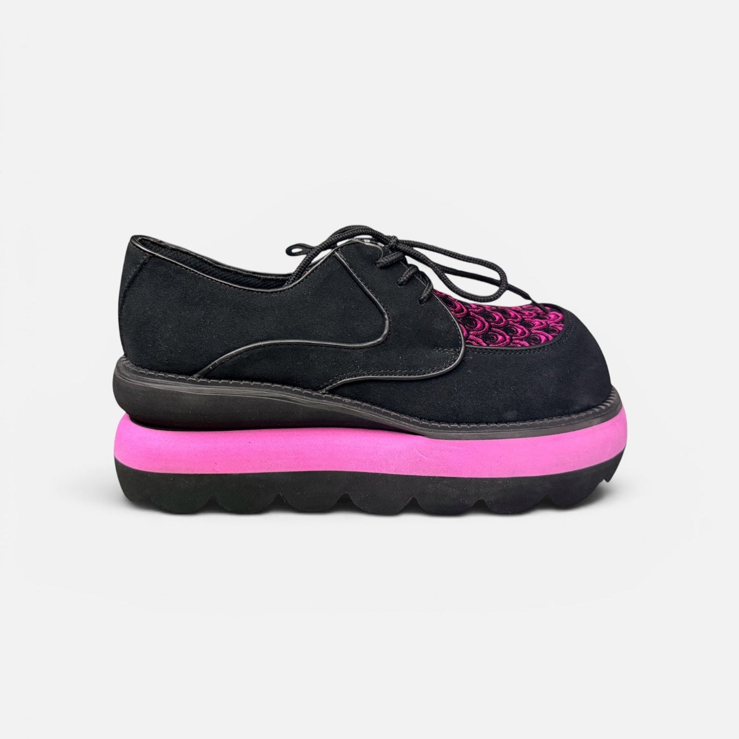 Black shoe with pink sole on a white background