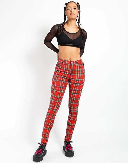 Person wearing red plaid pants and black top on a white background