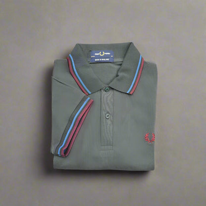 Folded gray polo shirt with colorful collar details on a white background